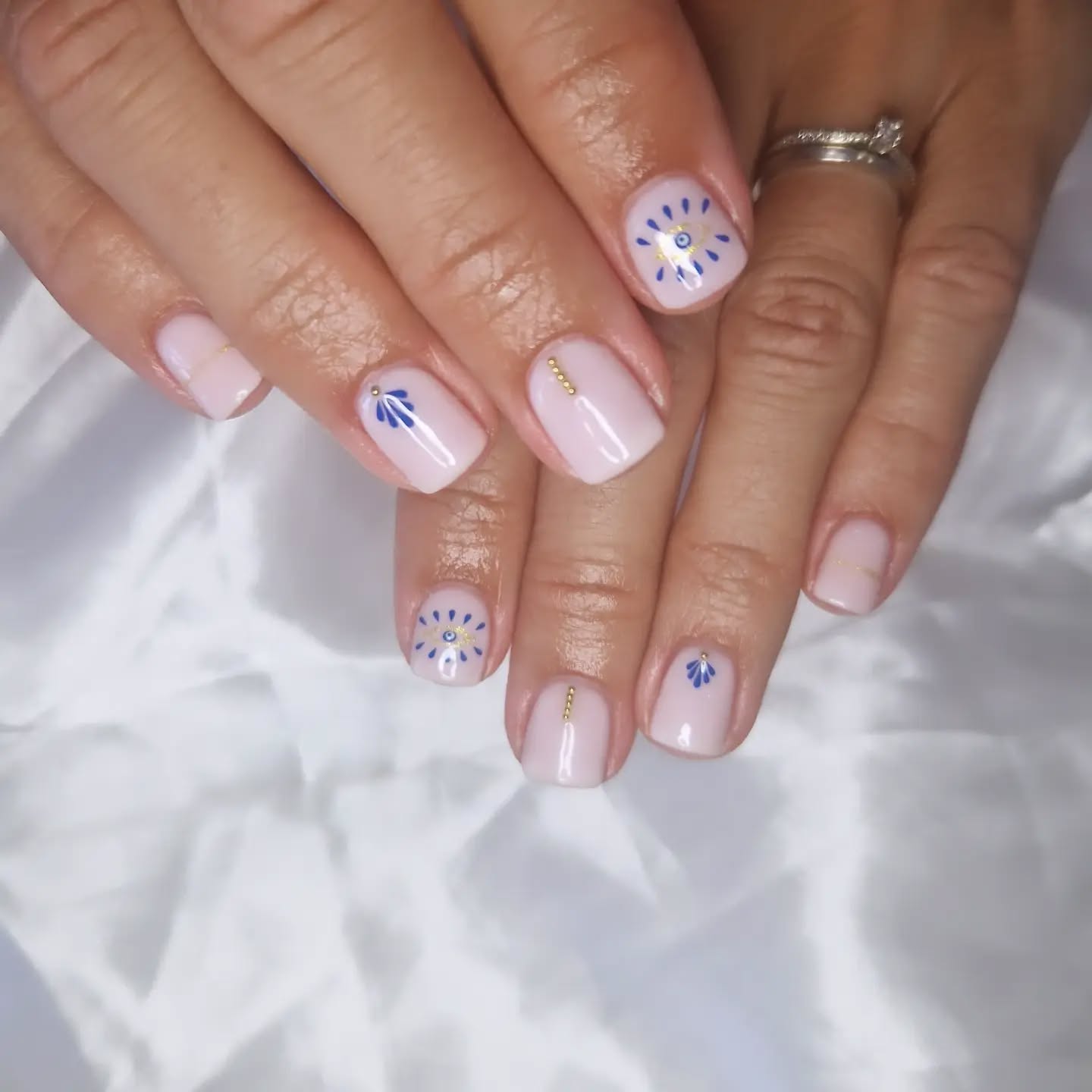 Nude laiteux, nail art bleu et détails dorés
